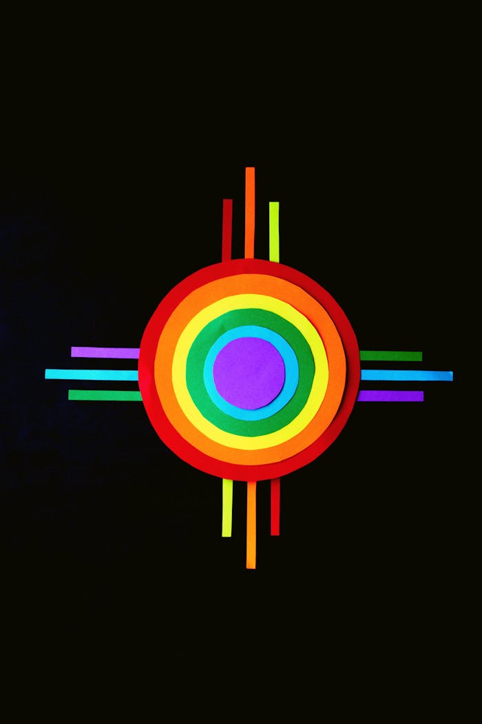 Colorful rainbow circle with geometric design on black background, symbolizing LGBTQ pride.